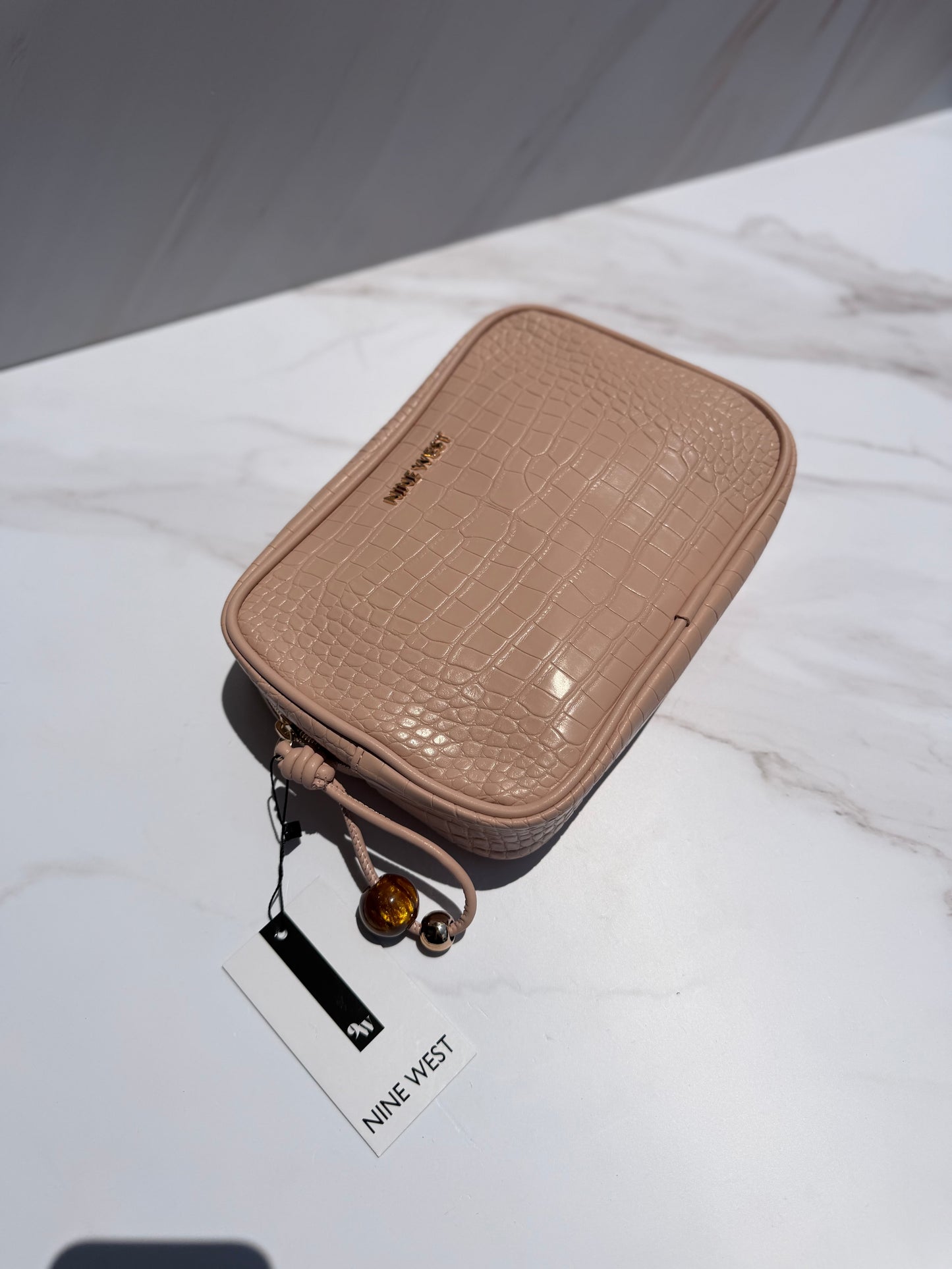 Cosmetiquera rosa Nine West con charm