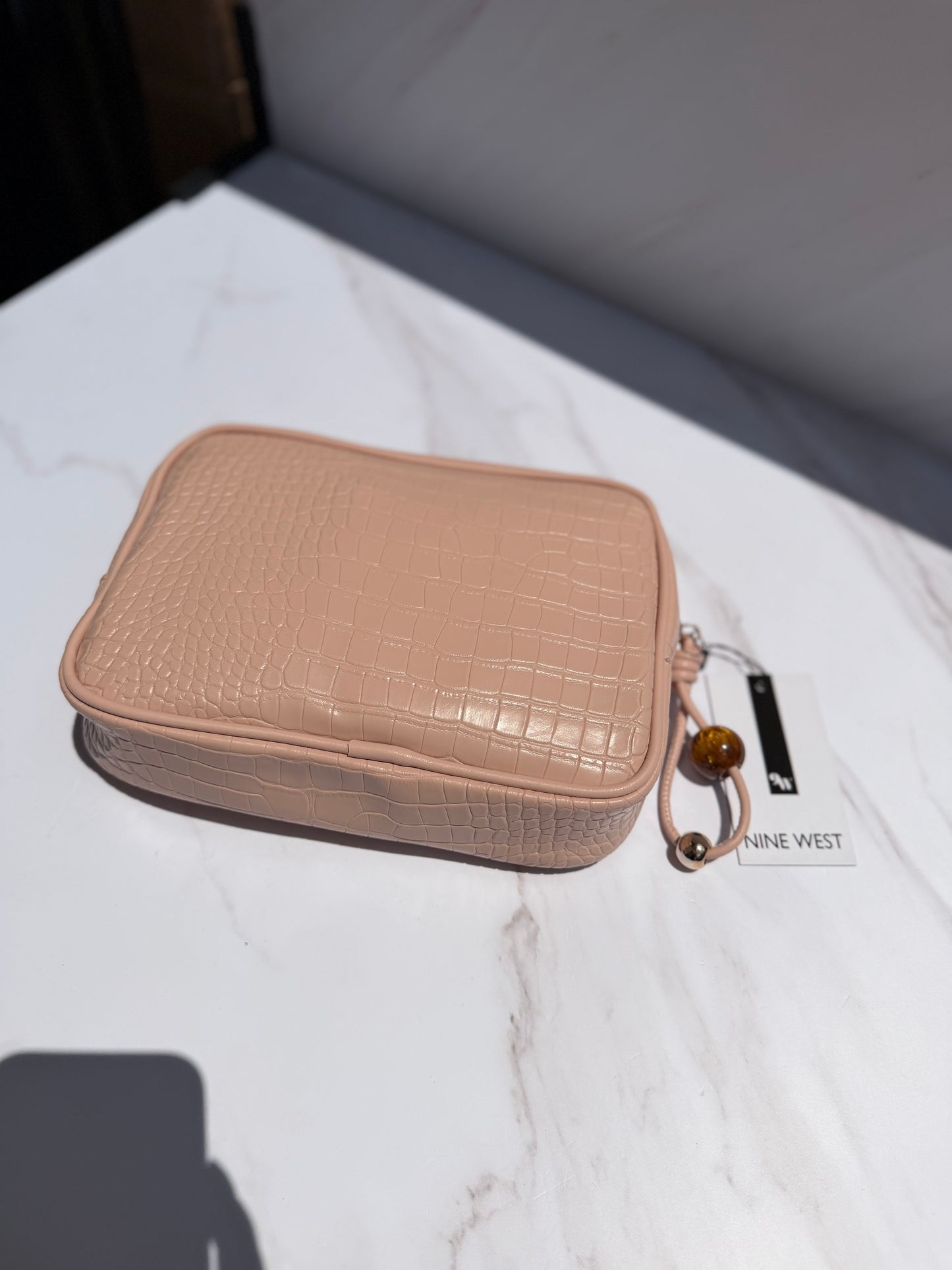 Cosmetiquera rosa Nine West con charm